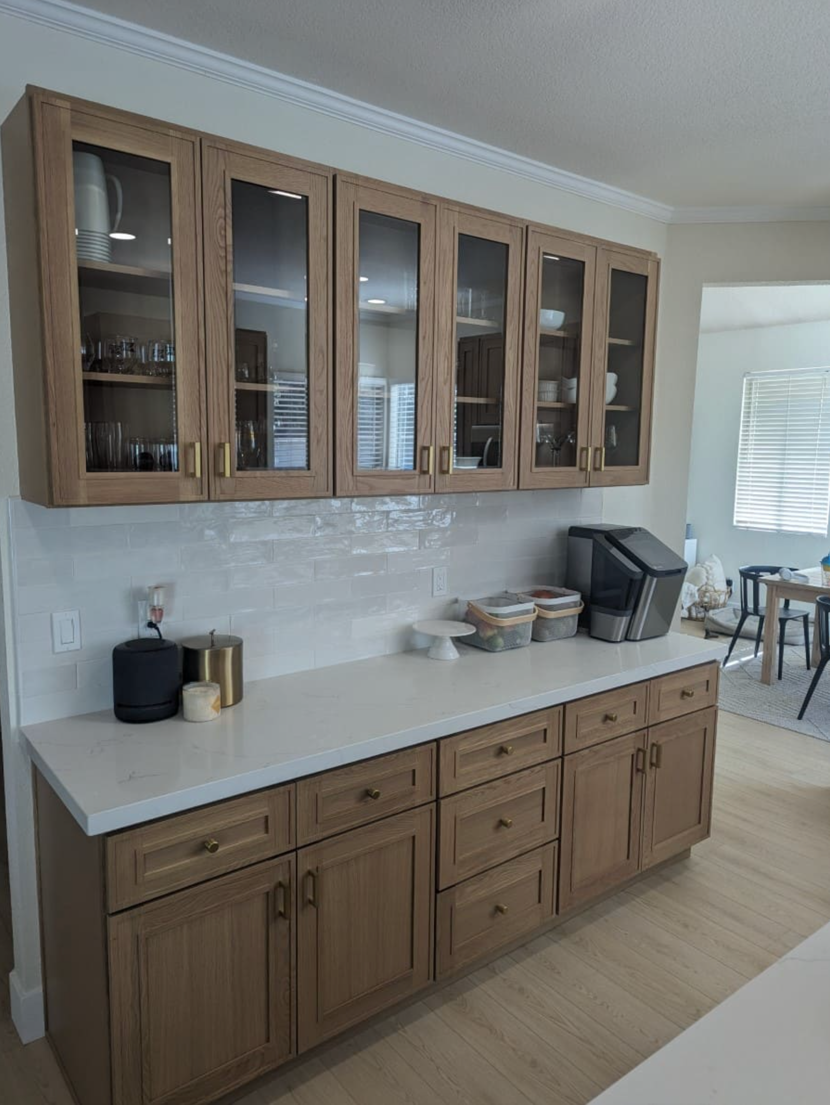 A kitchen with wooden cabinets and white counter tops