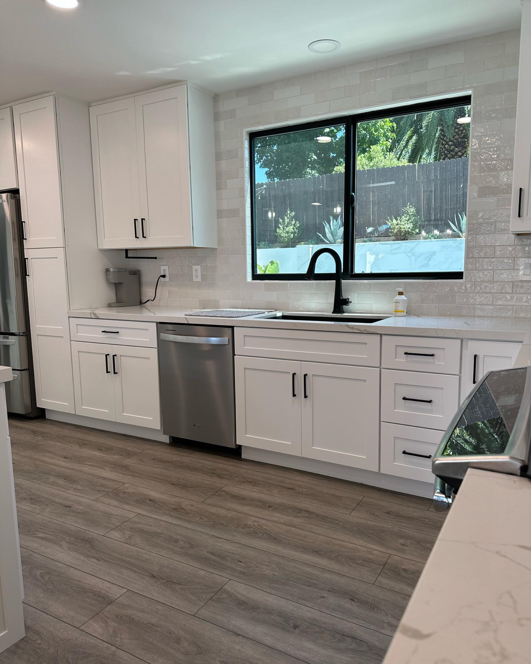 A kitchen with white cabinets and stainless steel appliances