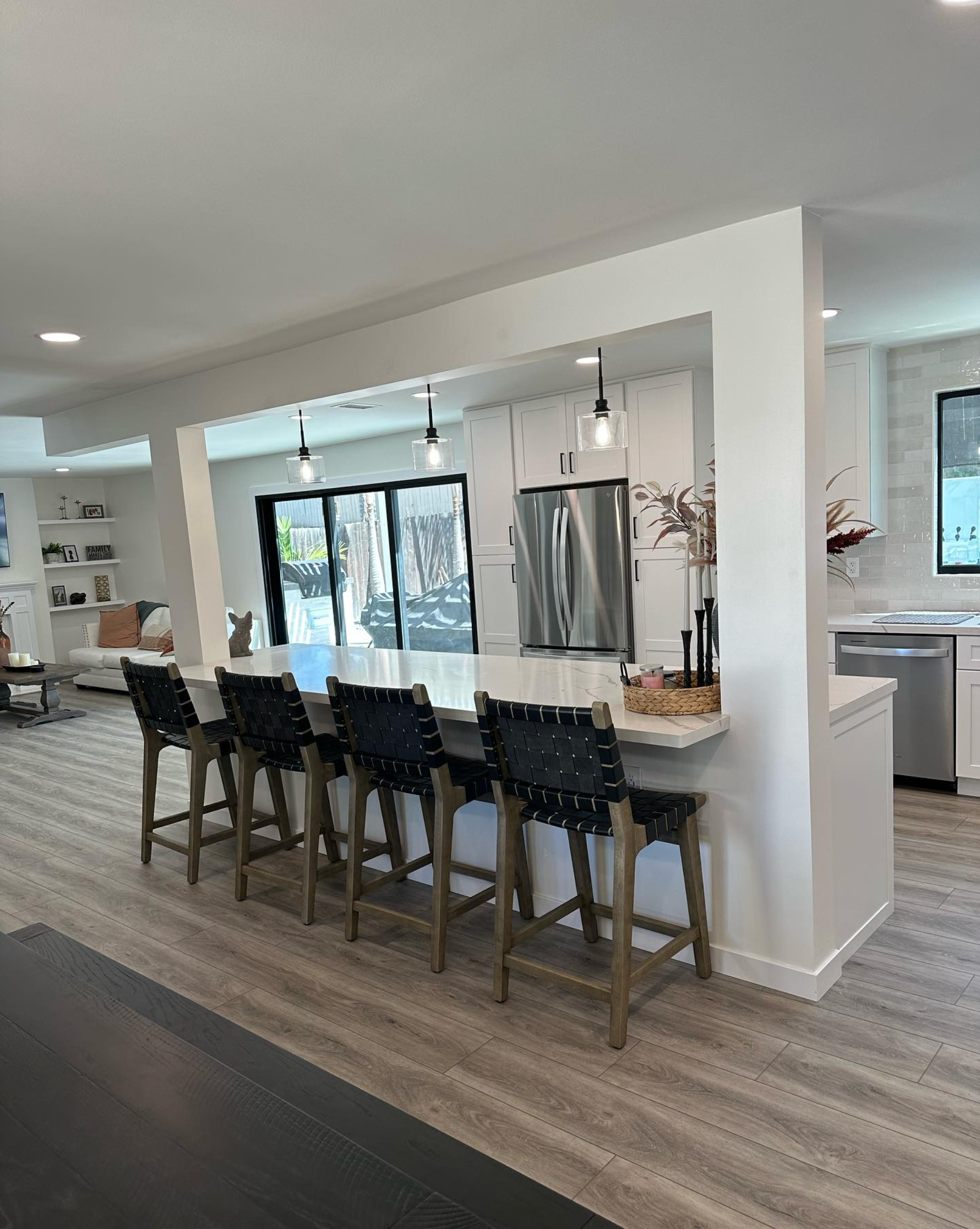 A kitchen with a long counter and stools in it.