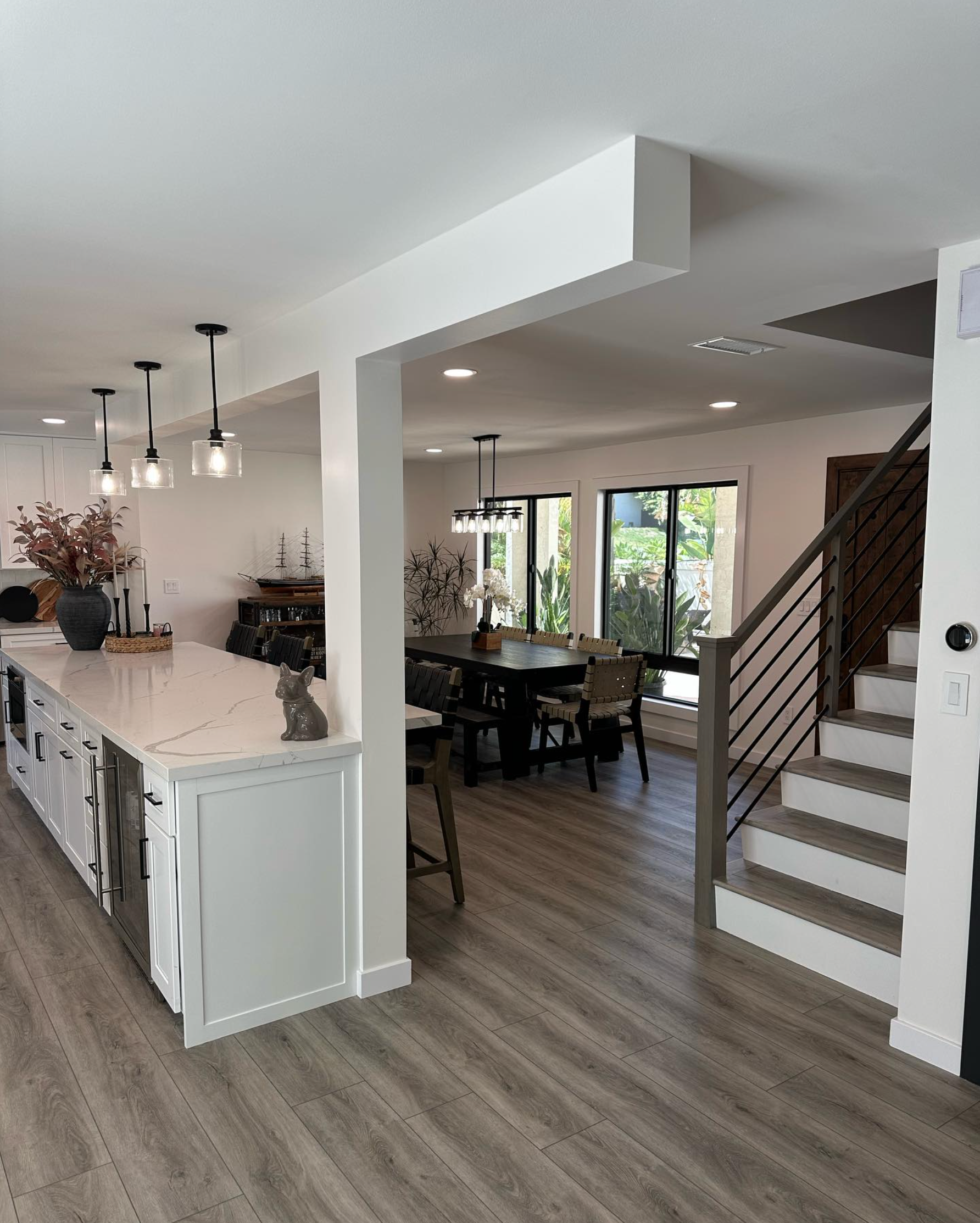 A kitchen and dining room in a house with stairs leading up to the second floor.