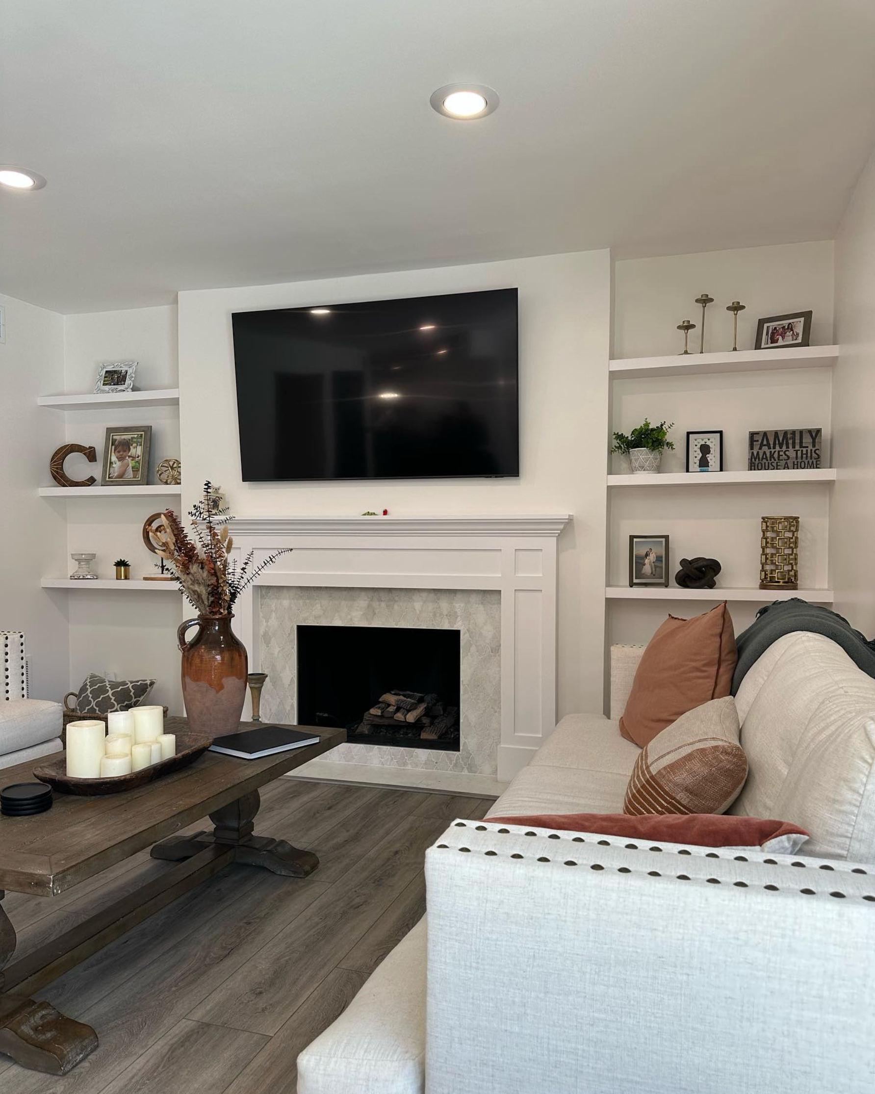 A living room with a fireplace and a flat screen tv