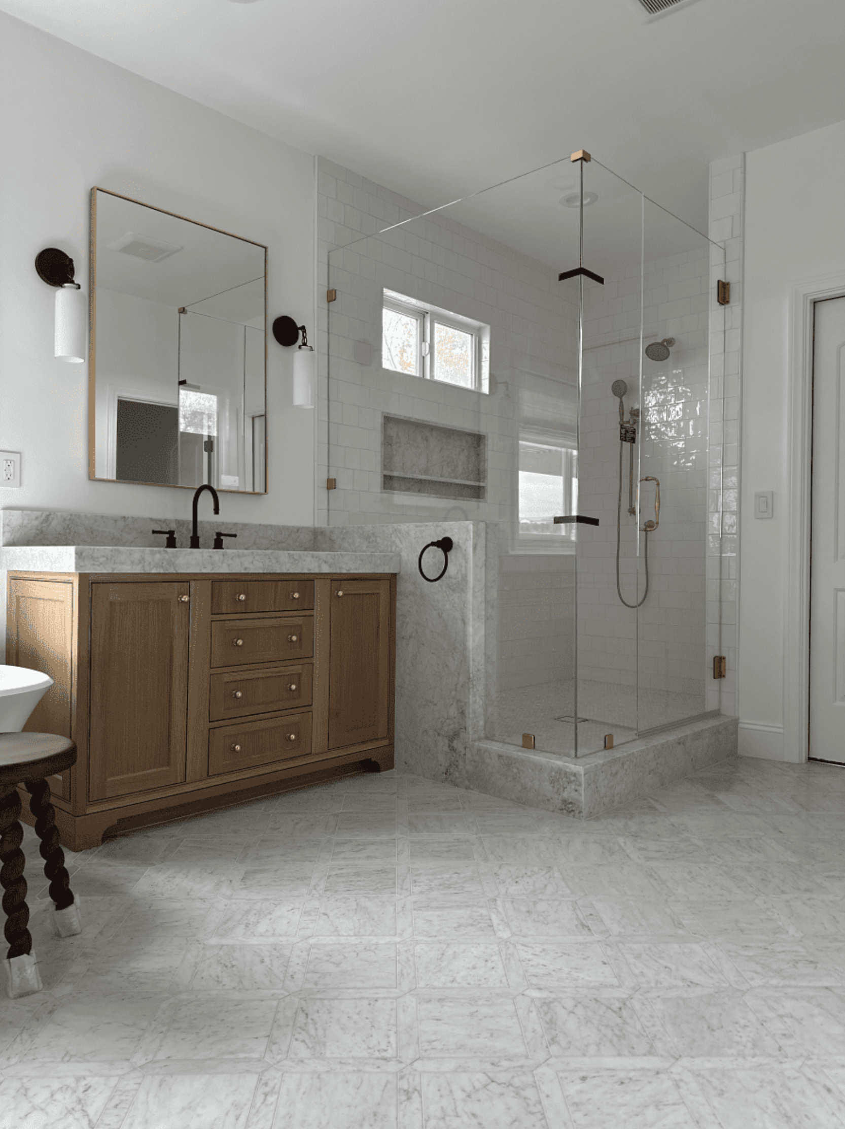 A bathroom with a walk in shower , sink and mirror.