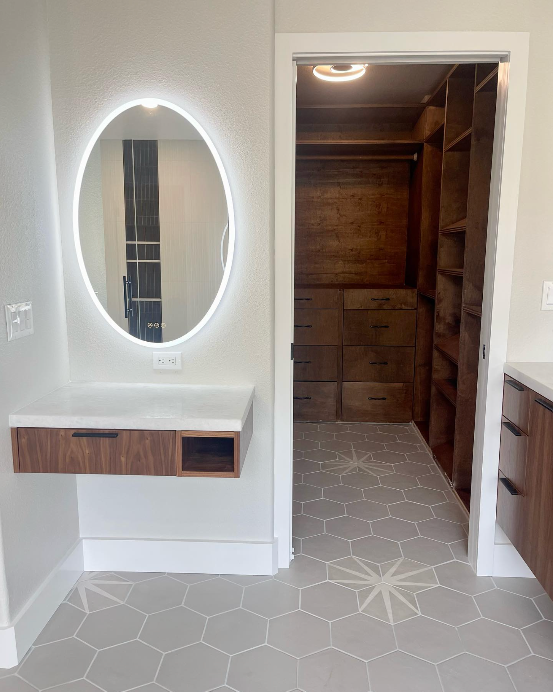 A bathroom with a mirror and a walk in closet