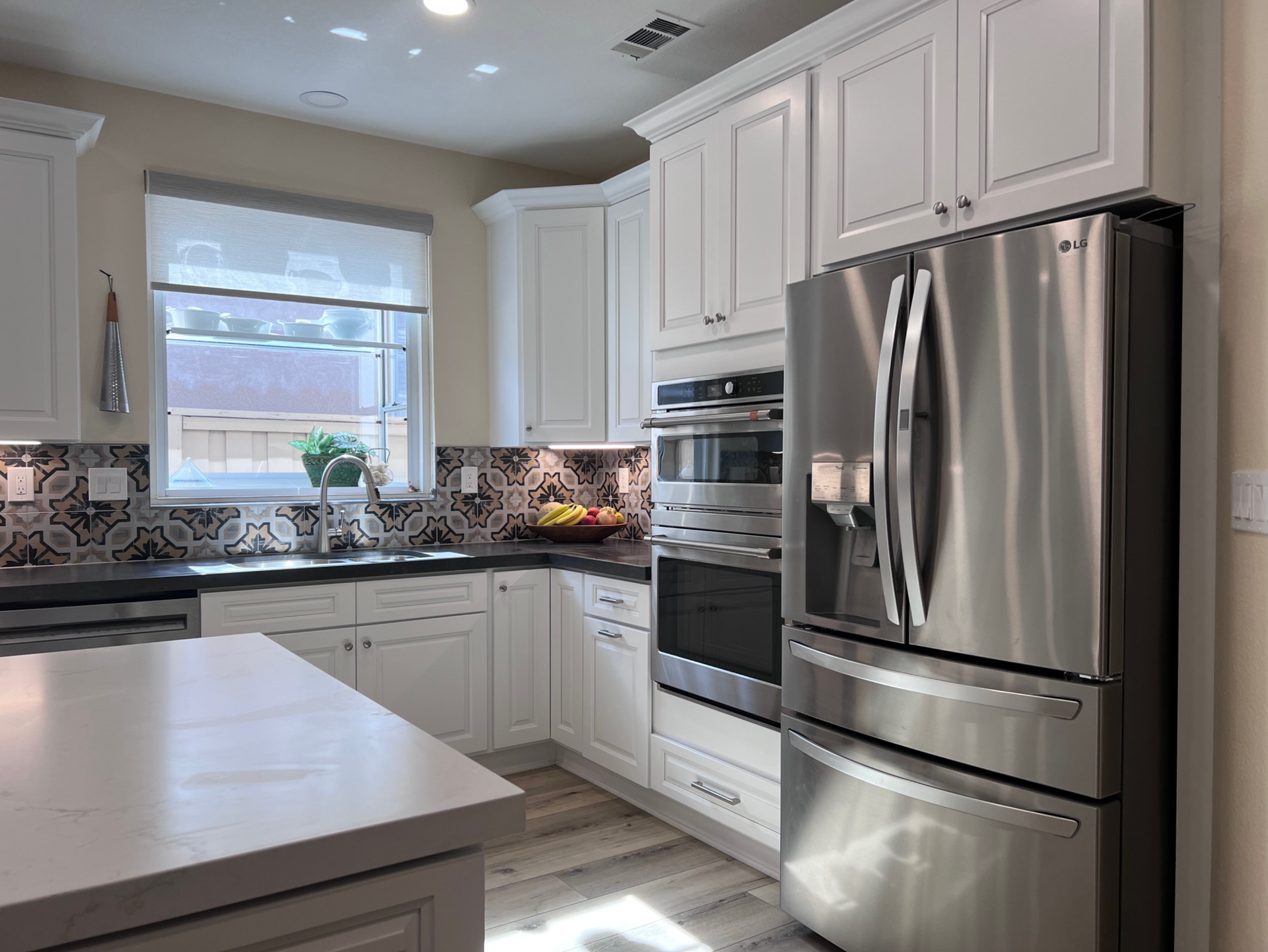 A kitchen with stainless steel appliances and white cabinets.