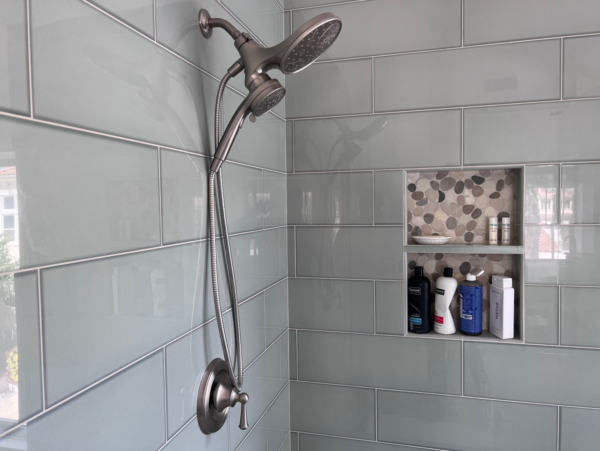 A shower head is hanging from the wall in a bathroom.