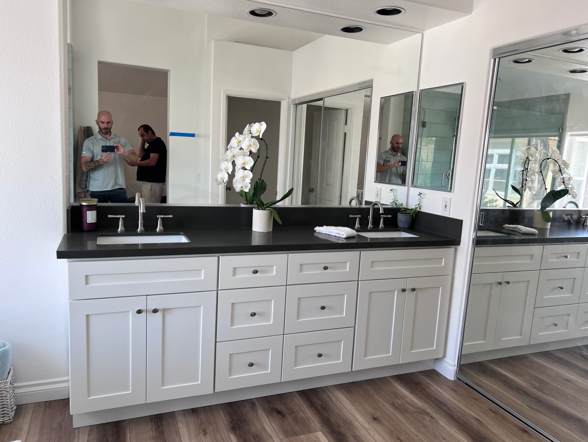 A bathroom with two sinks and a large mirror