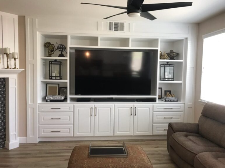 A living room with white cabinets and a flat screen tv