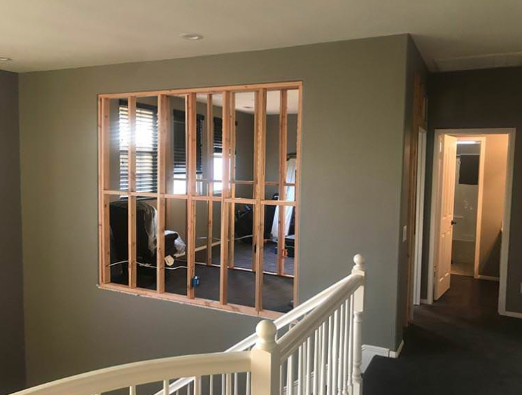 A room with a staircase and a window in the middle of it.