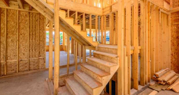 A wooden staircase in a house under construction.