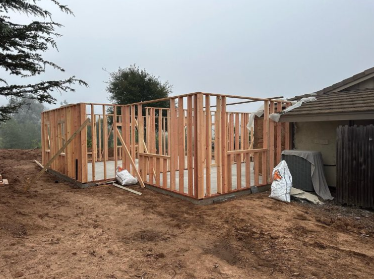A house is being built in the backyard of a house.