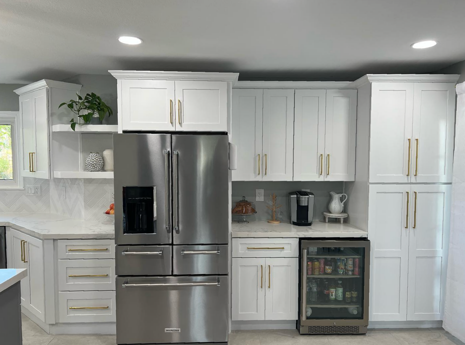 A kitchen with white cabinets and a stainless steel refrigerator.