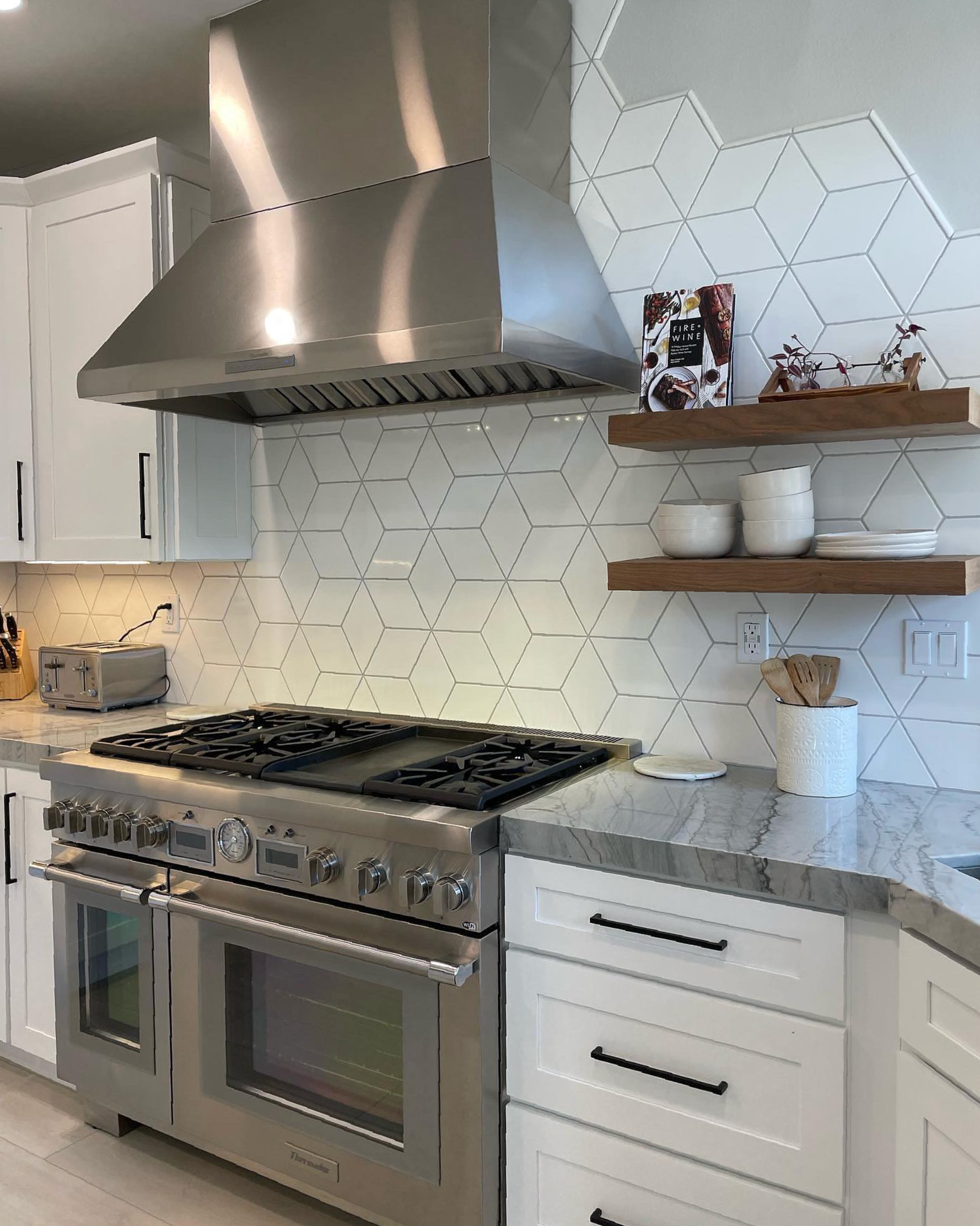 A kitchen with stainless steel appliances and white cabinets.