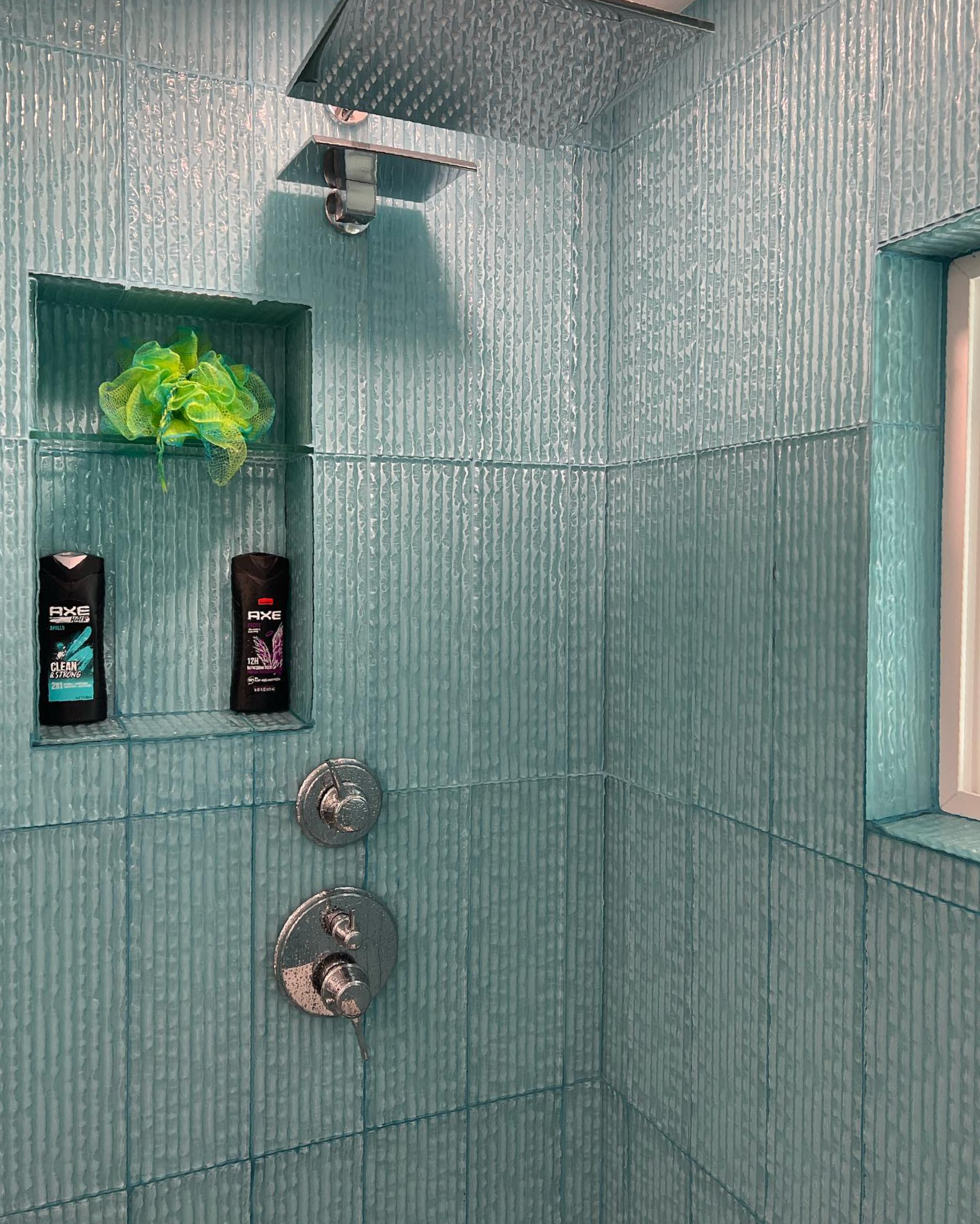 A bathroom with a shower head and a window.