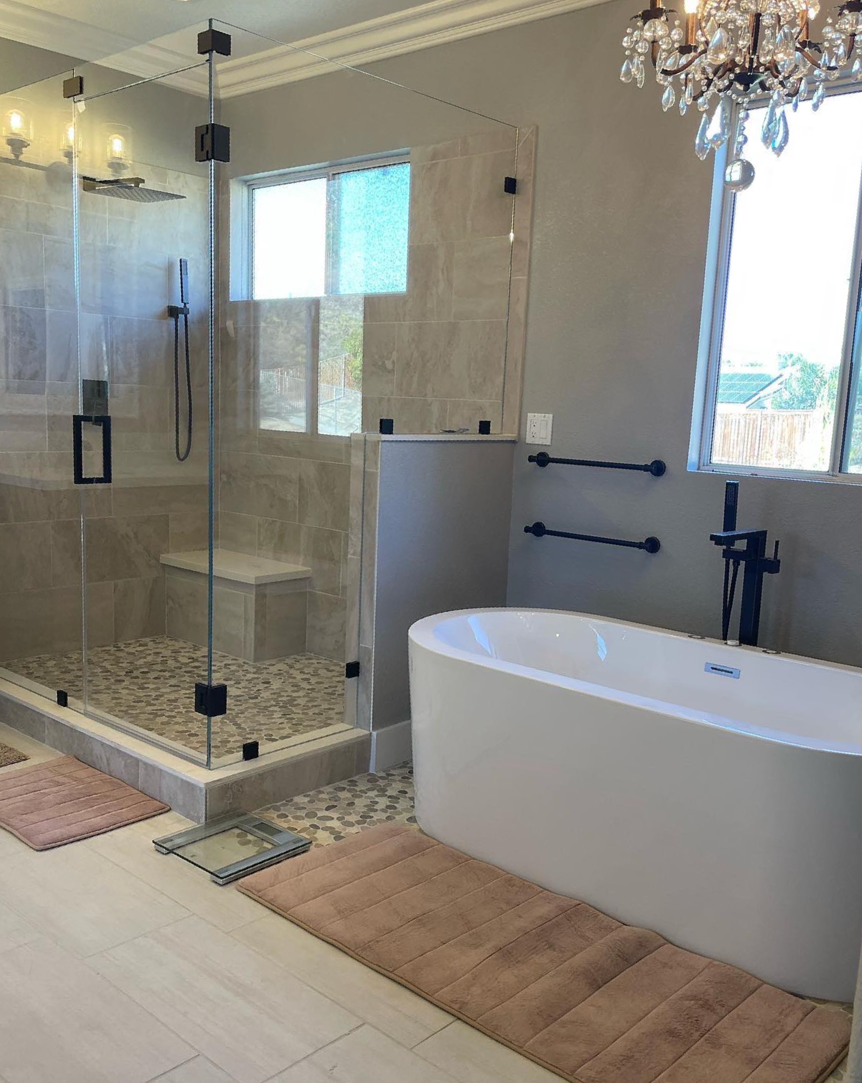 A bathroom with a tub , shower , and window.