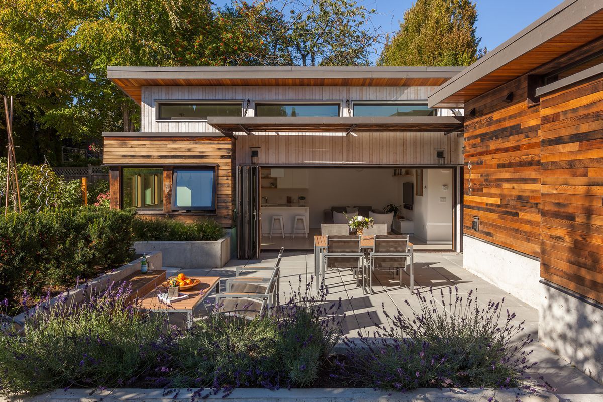 A modern house with a patio and a fire pit in front of it.