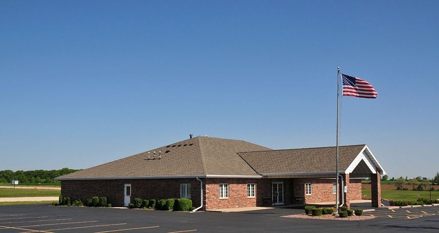 Brick building with American flag waving under a clear blue sky.