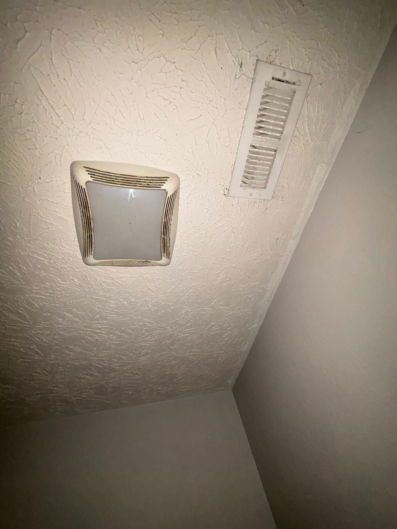 Light fixture and air vent on textured ceiling.