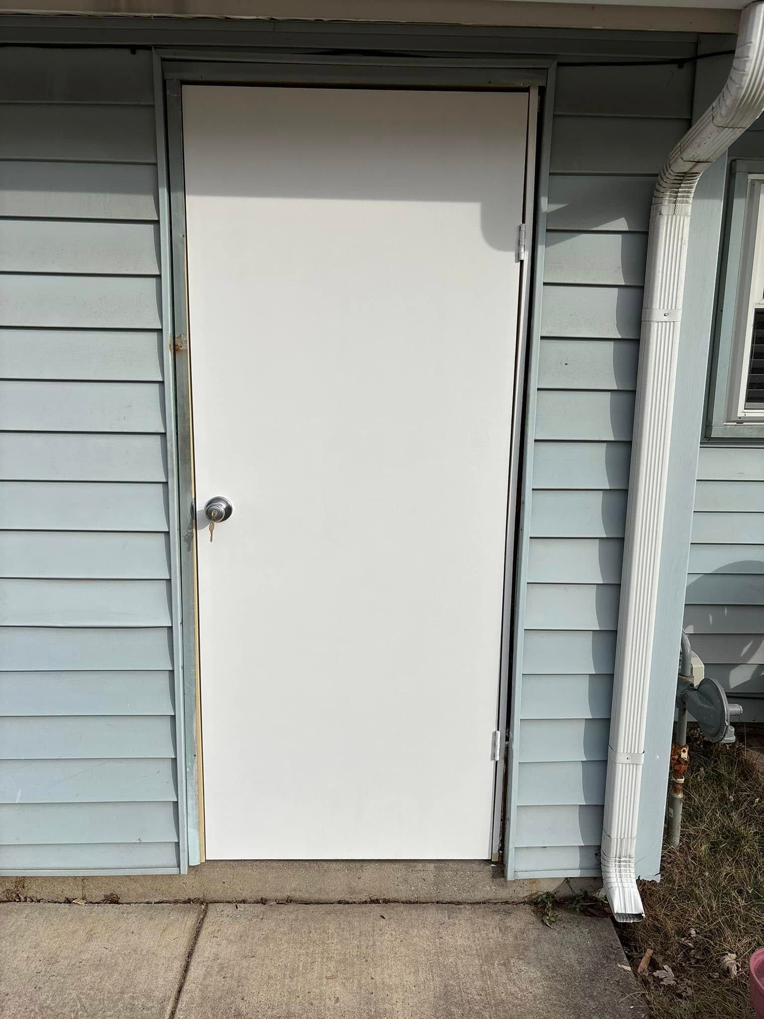 White door set in blue siding, exterior building.