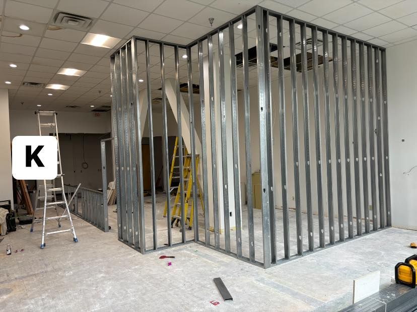 Construction site with metal studs framing walls and a ladder.