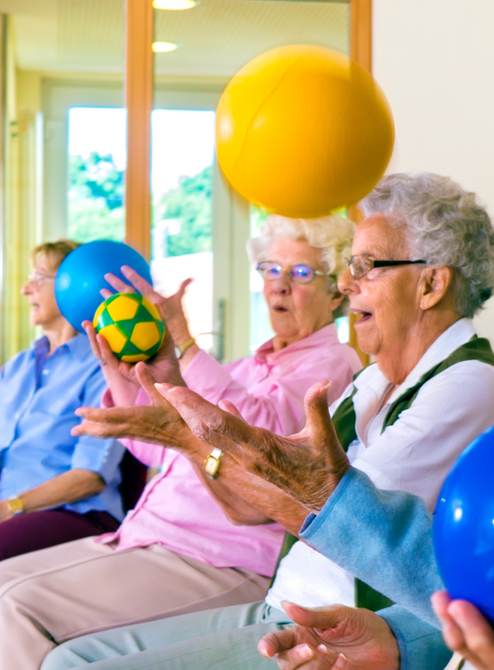 A group of elderly people are playing with balls