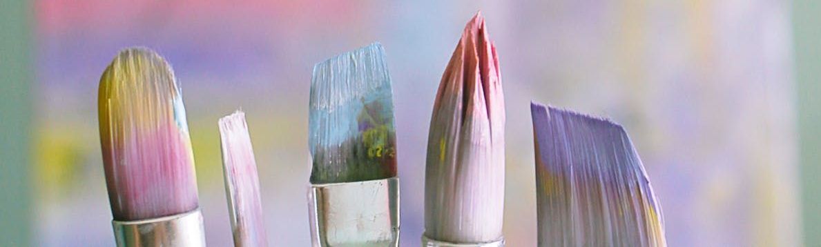 A close up of a bunch of paint brushes on a table.