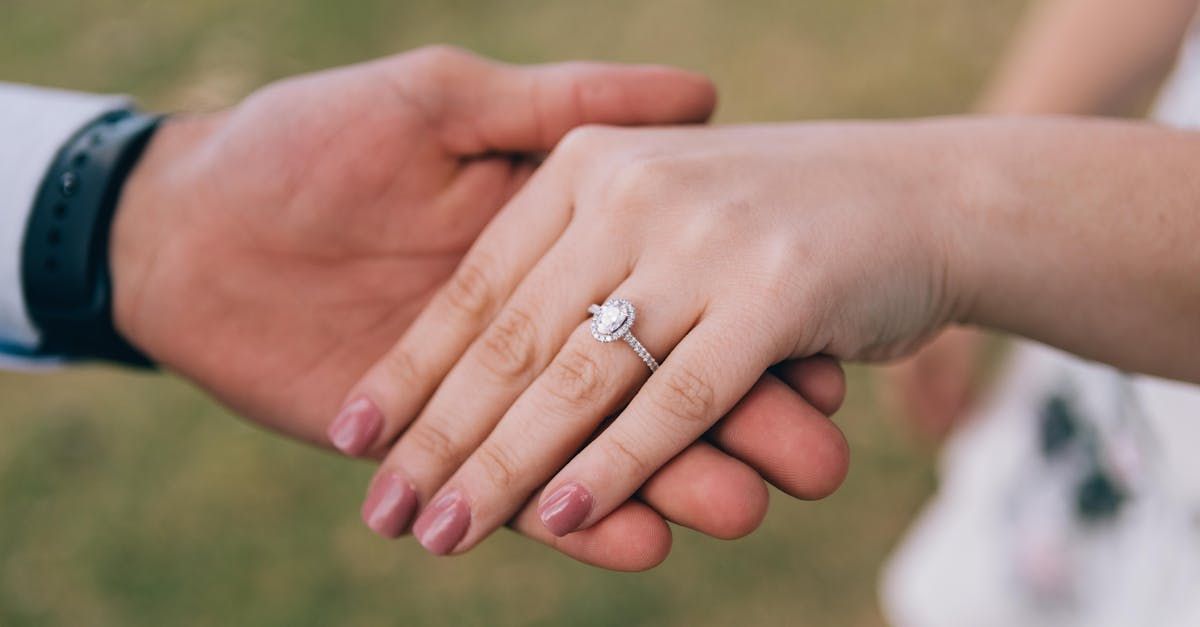 A man is putting an engagement ring on a woman 's finger.