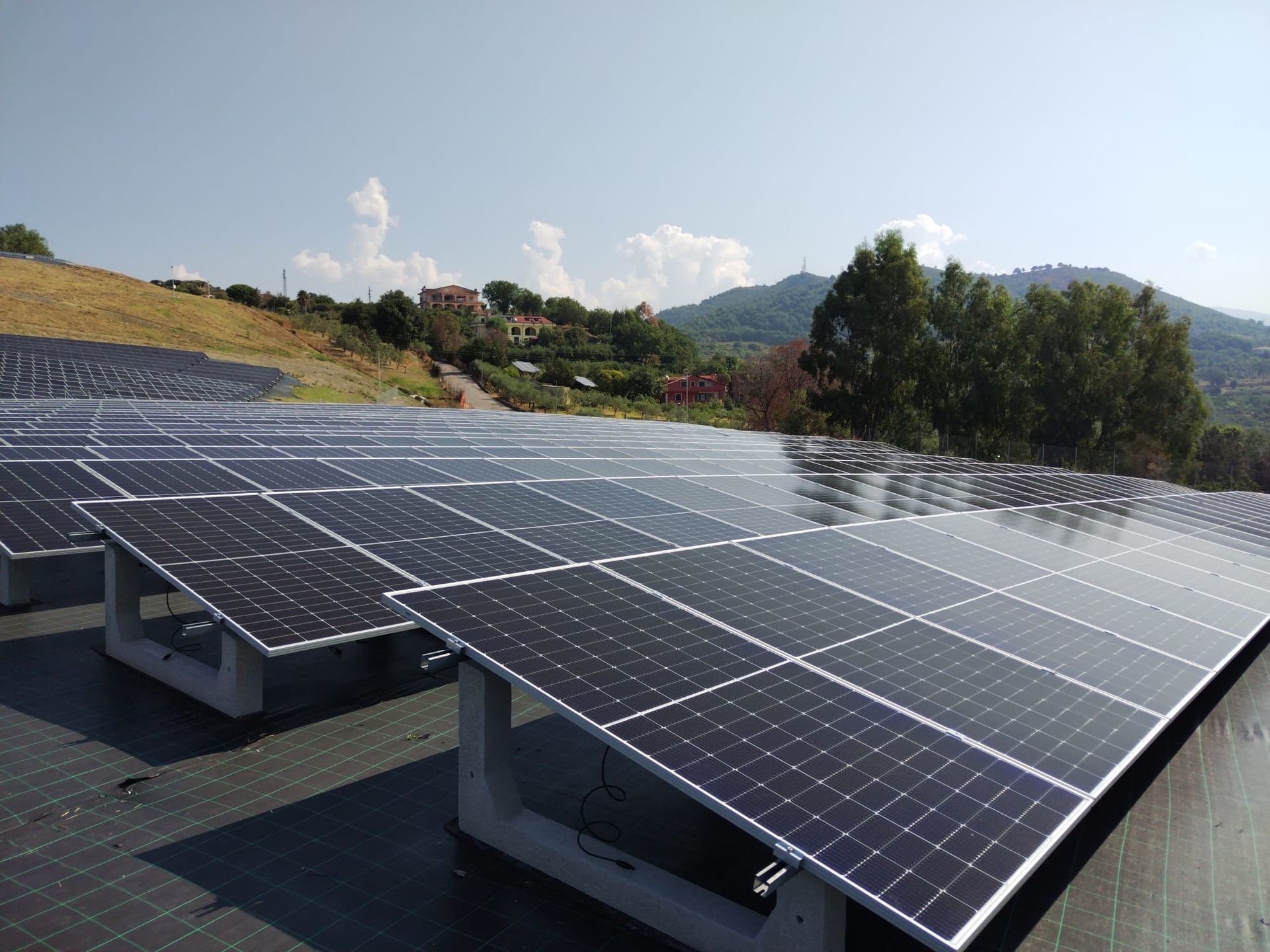 Una fila di pannelli solari su un tetto con le montagne sullo sfondo