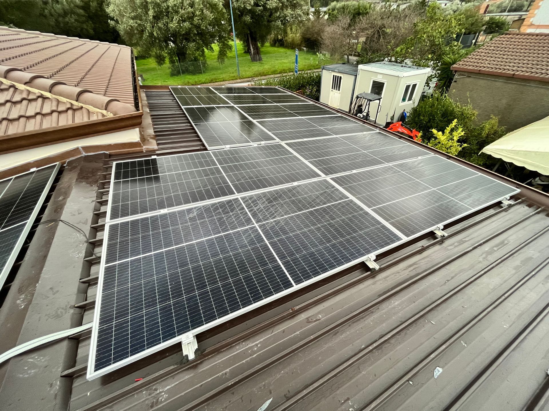 Una fila di pannelli solari è posizionata in cima a un tetto.