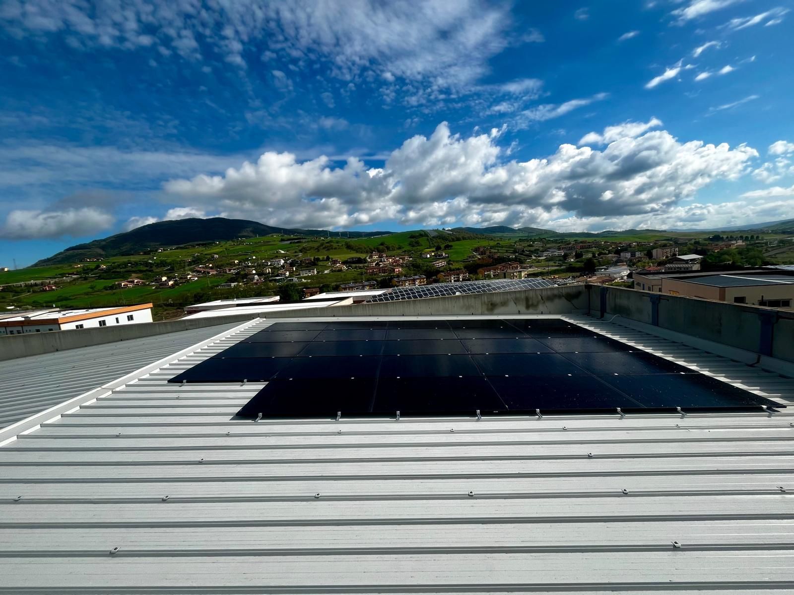 Una fila di pannelli solari è posizionata in cima a un tetto.