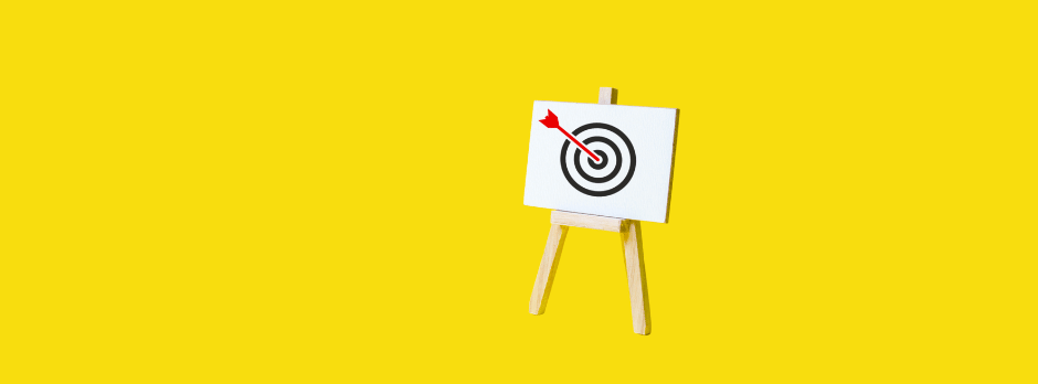 A dart board with an arrow in the center on a yellow background.