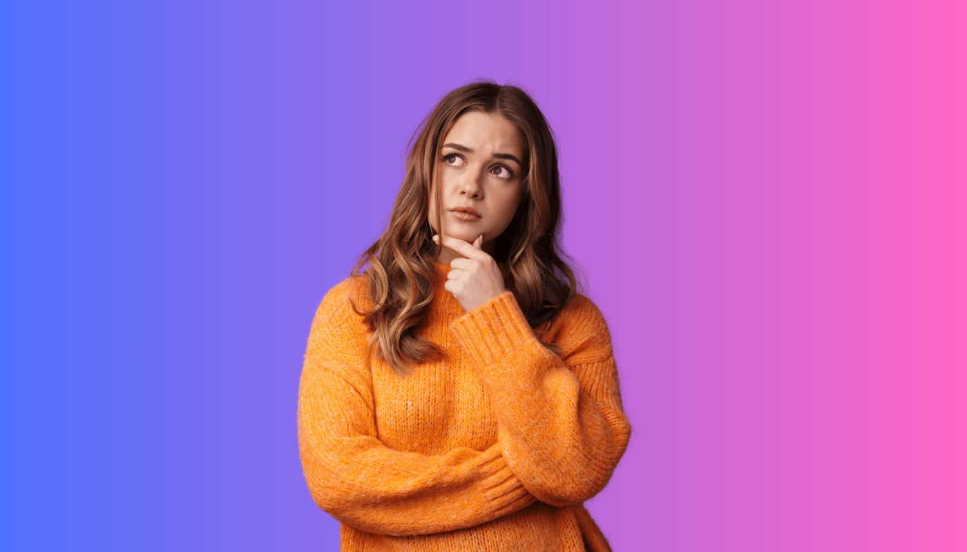 A woman in an orange sweater is thinking and looking up.