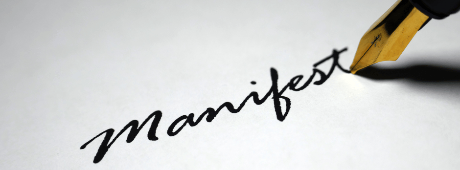 A fountain pen is writing the word manifest on a piece of paper.