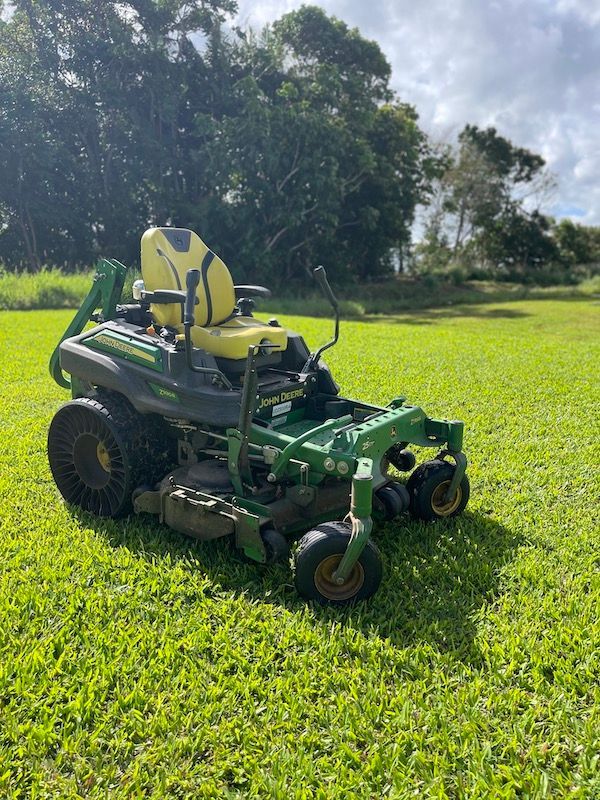 Ride On Lawn Mower Parked in a Driveway — Gardeners in Innisfail, QLD