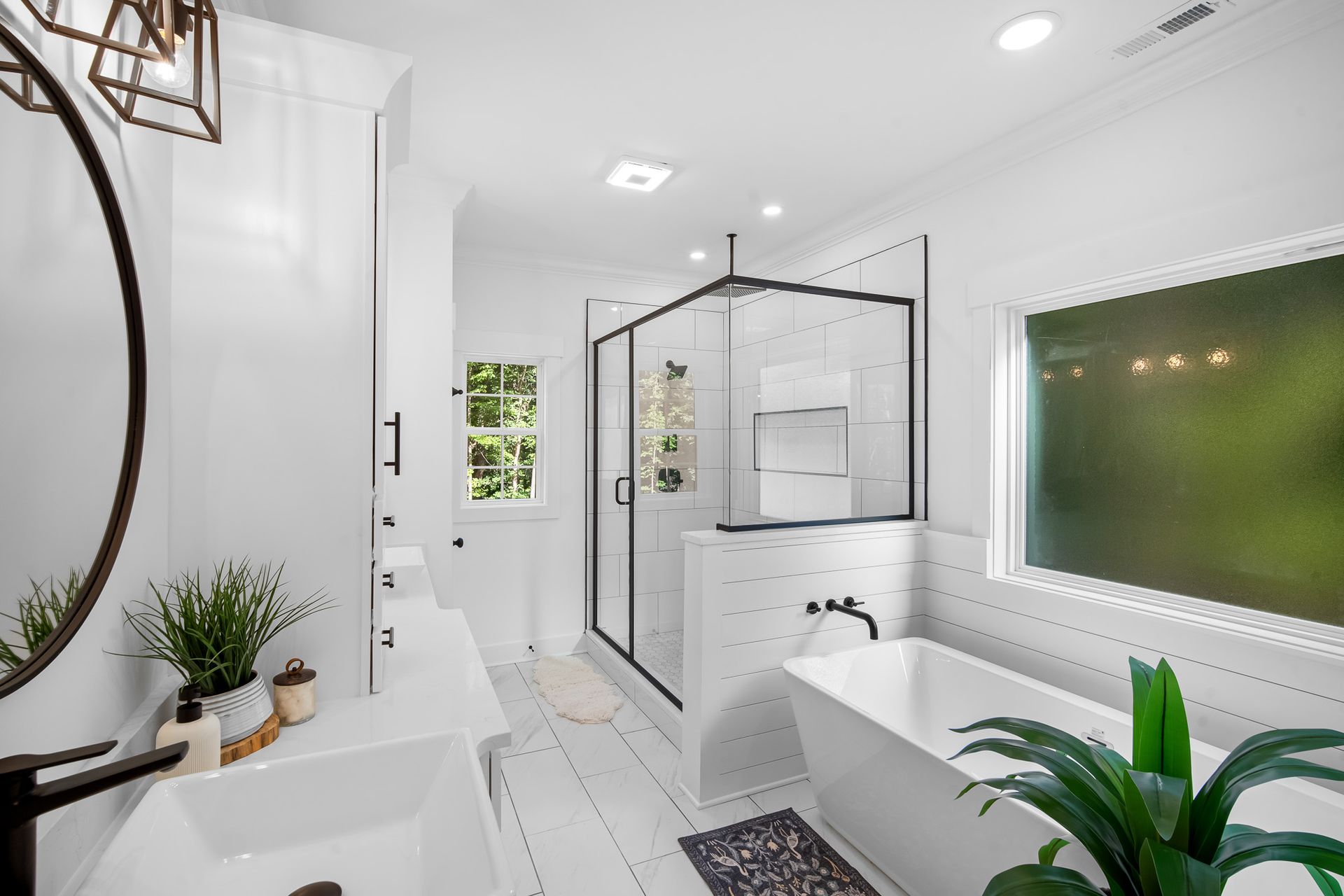 A bathroom with a tub , sink , shower and mirror.