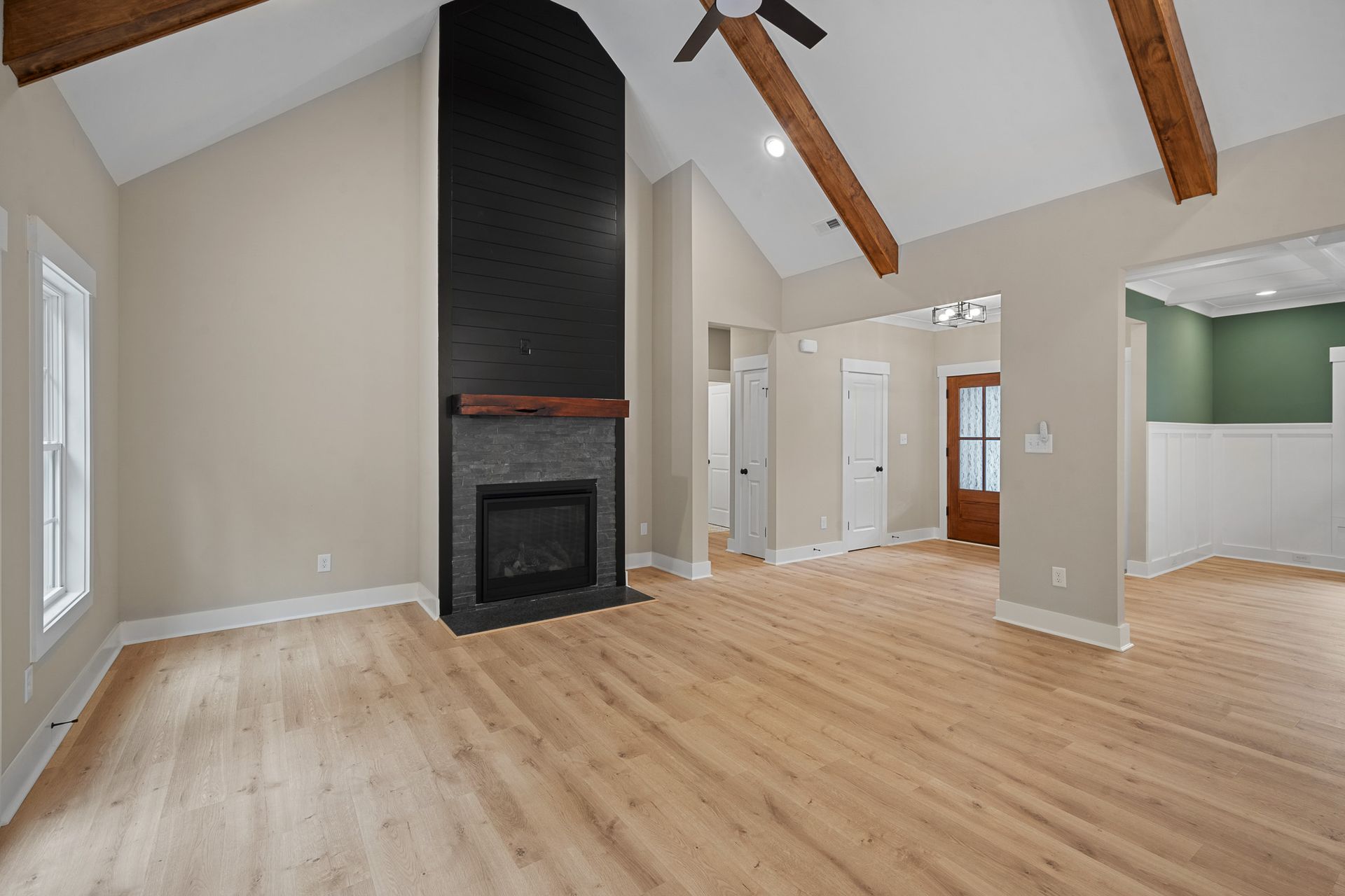 An empty living room with hardwood floors and a fireplace.