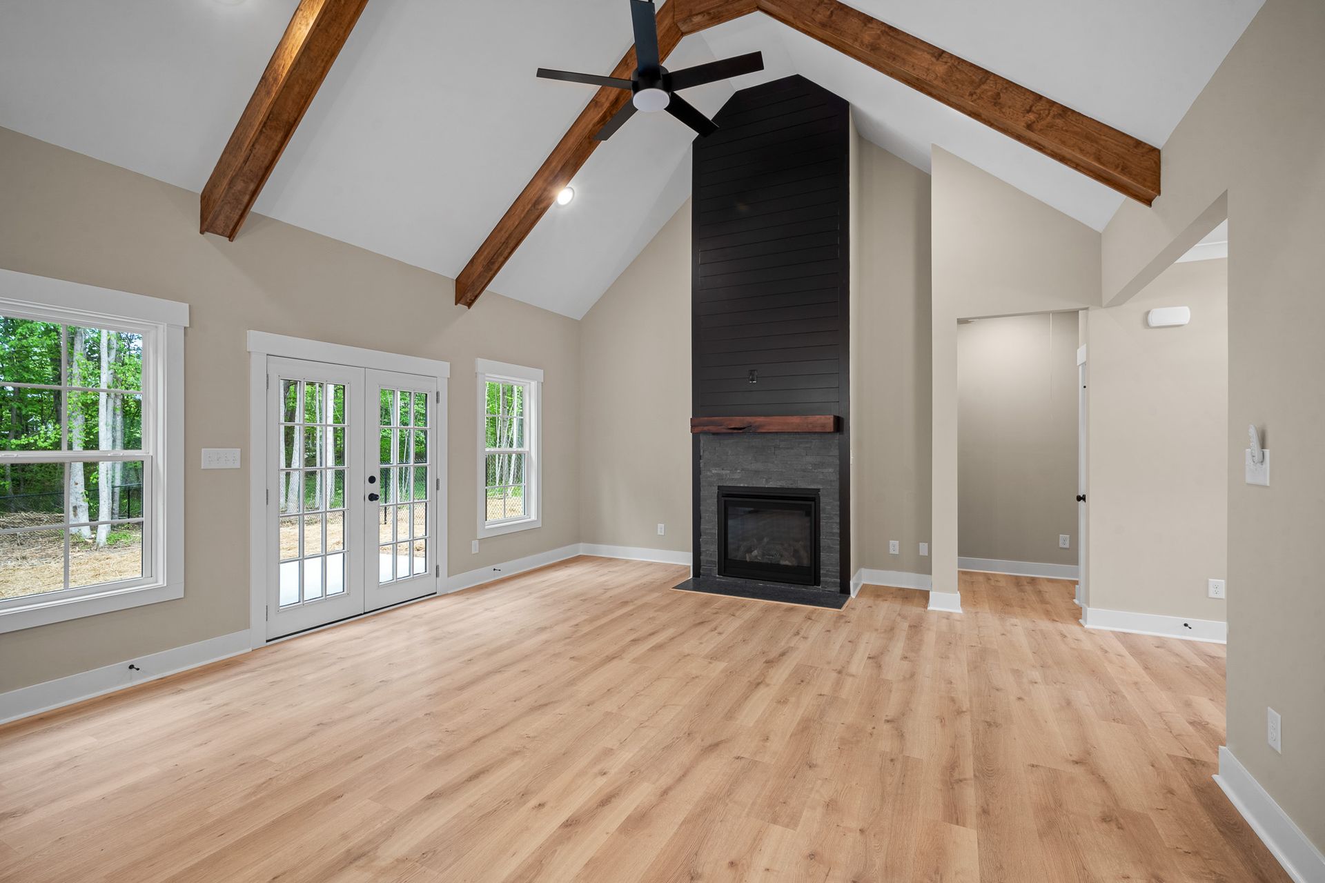 An empty living room with hardwood floors and a fireplace.