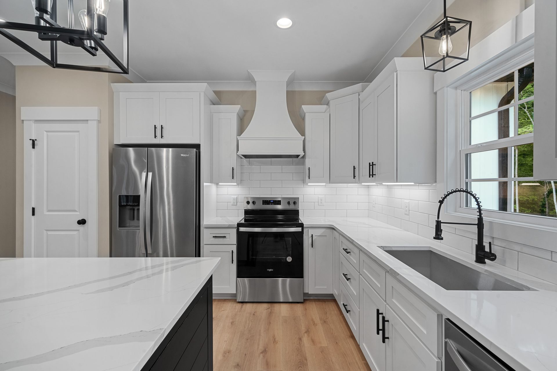 A kitchen with white cabinets and stainless steel appliances
