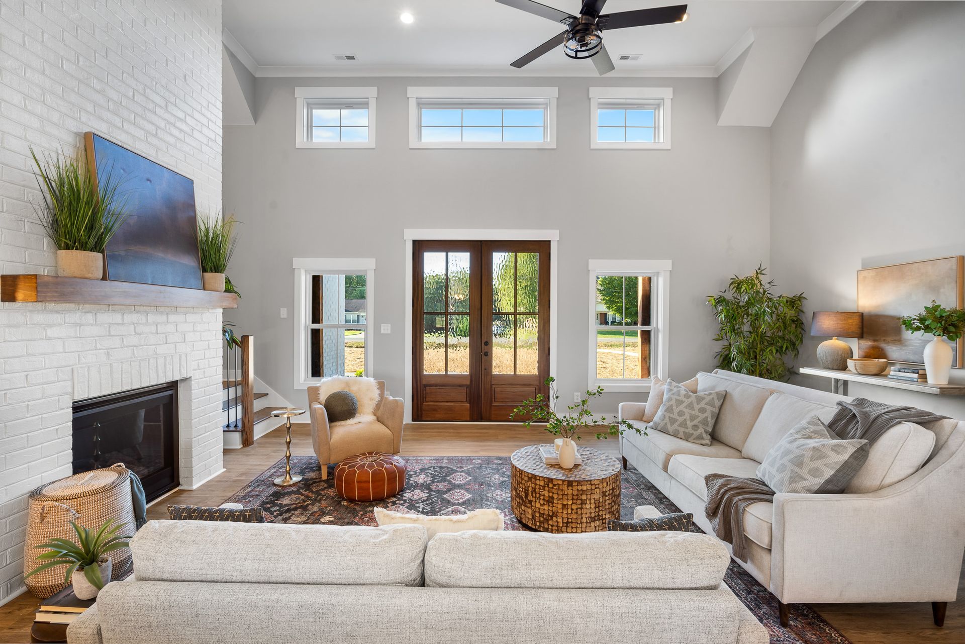A living room with a couch , fireplace , and ceiling fan.