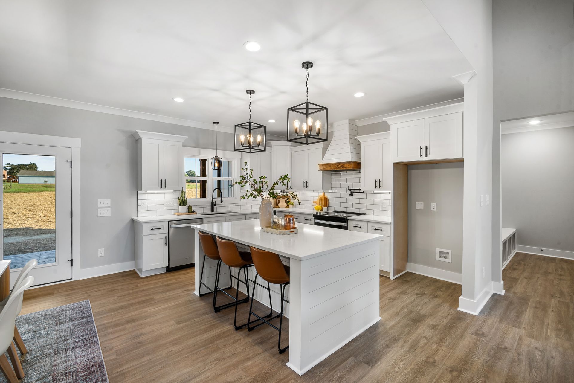 A kitchen in a house with white cabinets and a large island.