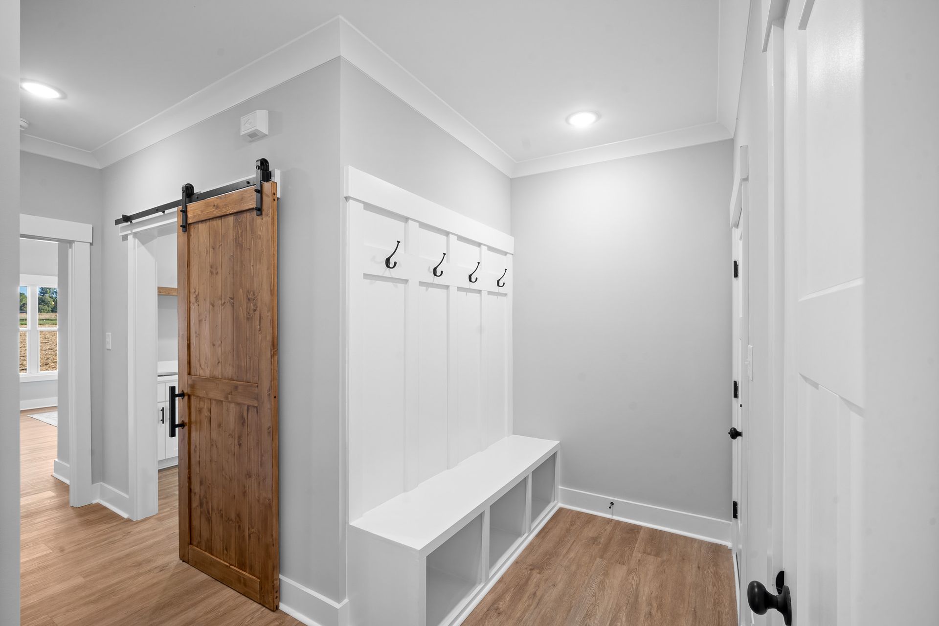 A hallway with a sliding barn door and a bench.