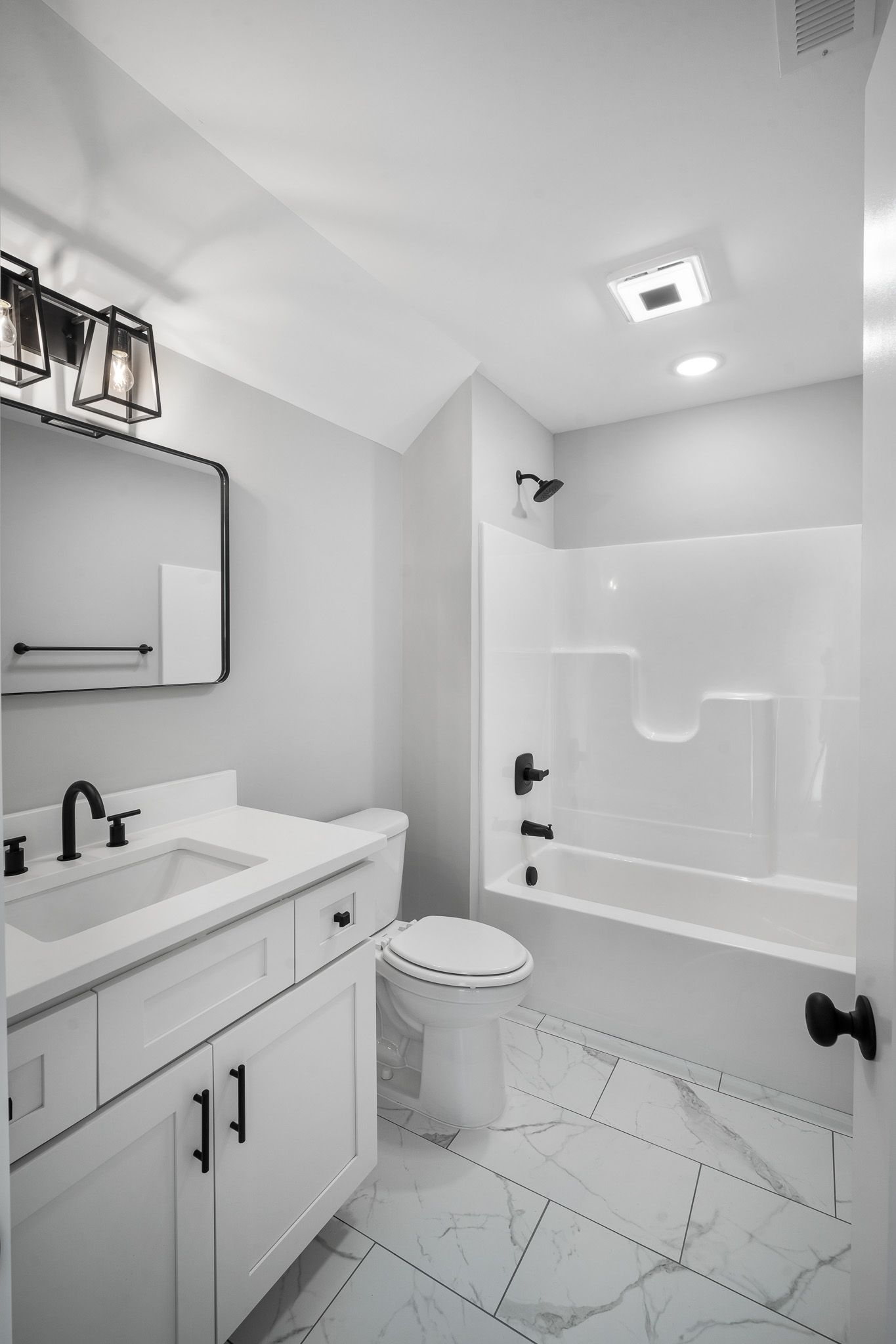 A bathroom with a sink , toilet , bathtub and mirror.