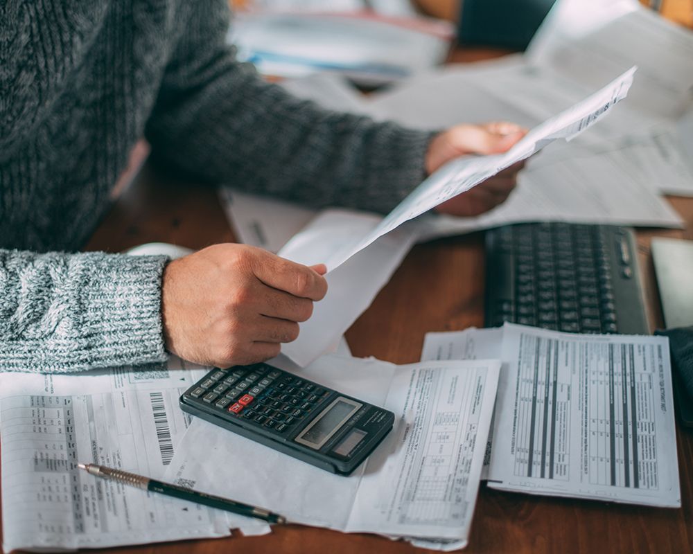 Man Sitting with Papers and a Calculator