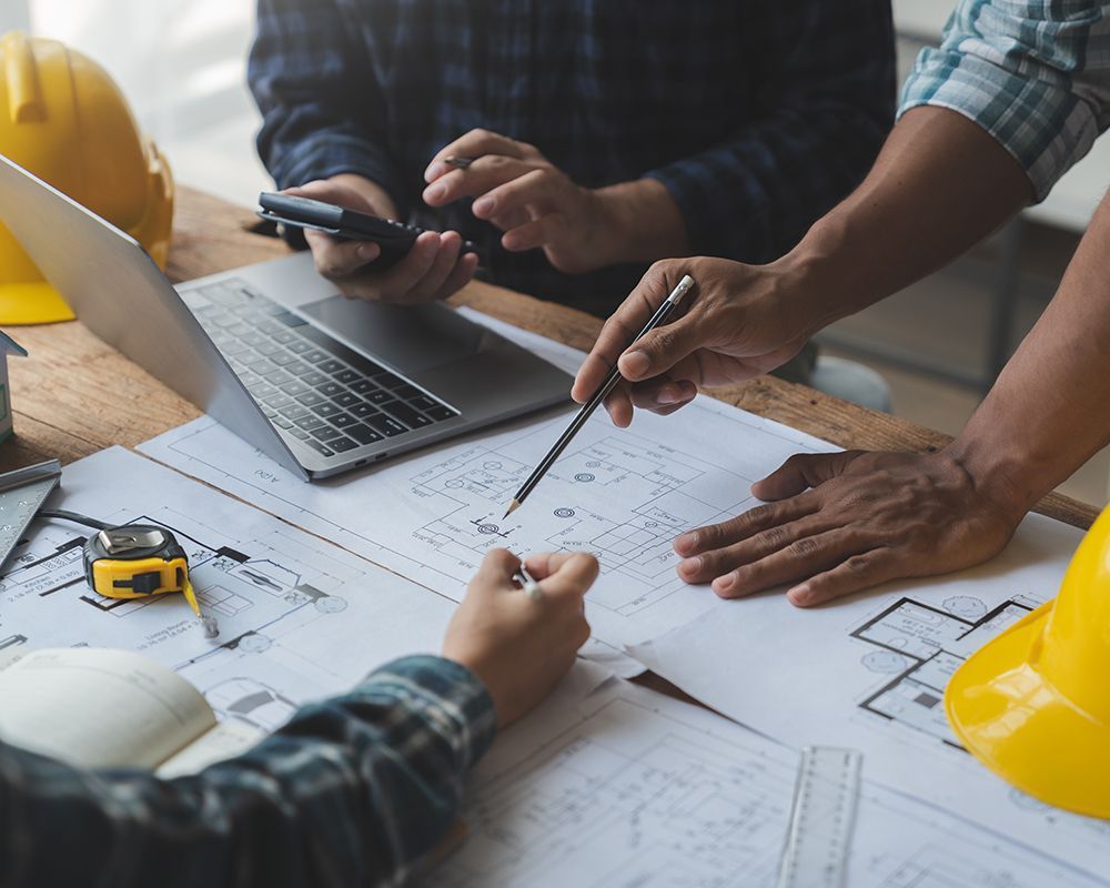 Worker Planning and Writing on a Blueprint