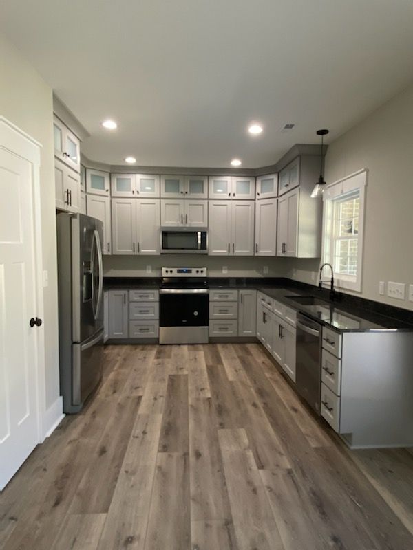 A kitchen with white cabinets and stainless steel appliances