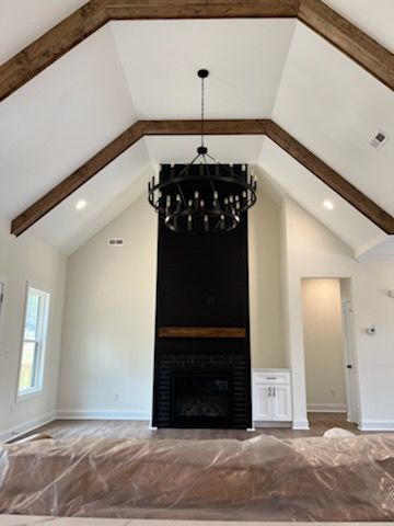 A living room with a fireplace and a chandelier hanging from the ceiling