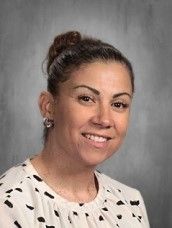 a woman in a white shirt is smiling for a picture .