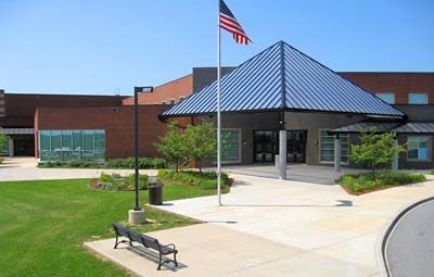 an american flag is flying in front of a school building .