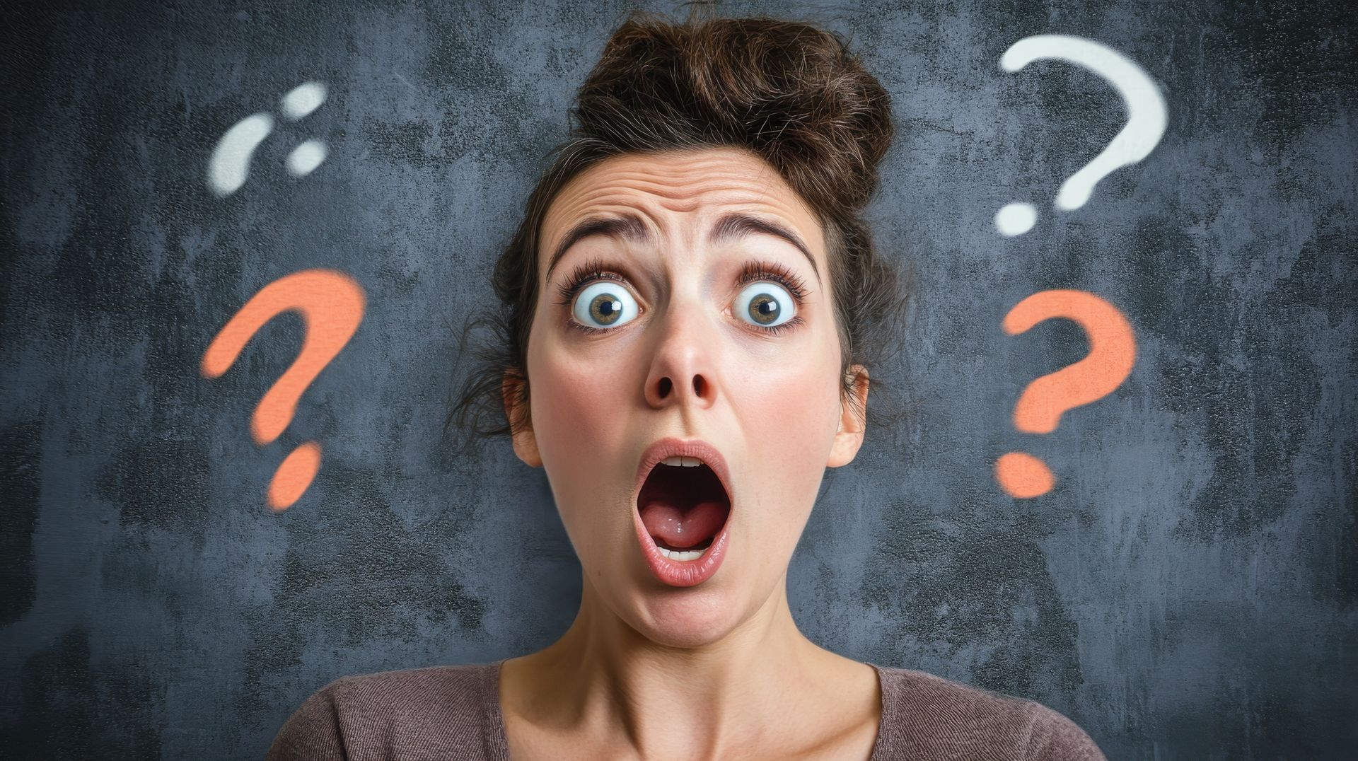 Woman with surprised expression, mouth open, looking at the viewer; question marks floating around her.