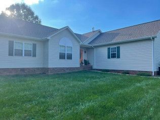 A large white house with a lush green lawn in front of it.
