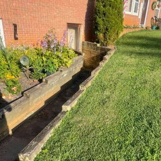 A brick house with a wooden planter in front of it.